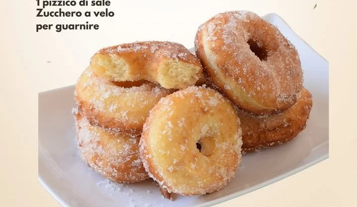 Graffe soffici alle patate appena fritte e spolverate di zucchero a velo.
