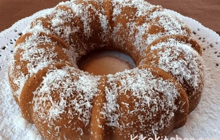Fetta di ciambella al cioccolato su piatto bianco decorata con zucchero a velo