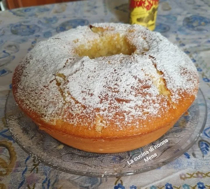 Ciambella morbidissima aromatizzata con liquore Strega su un piatto.