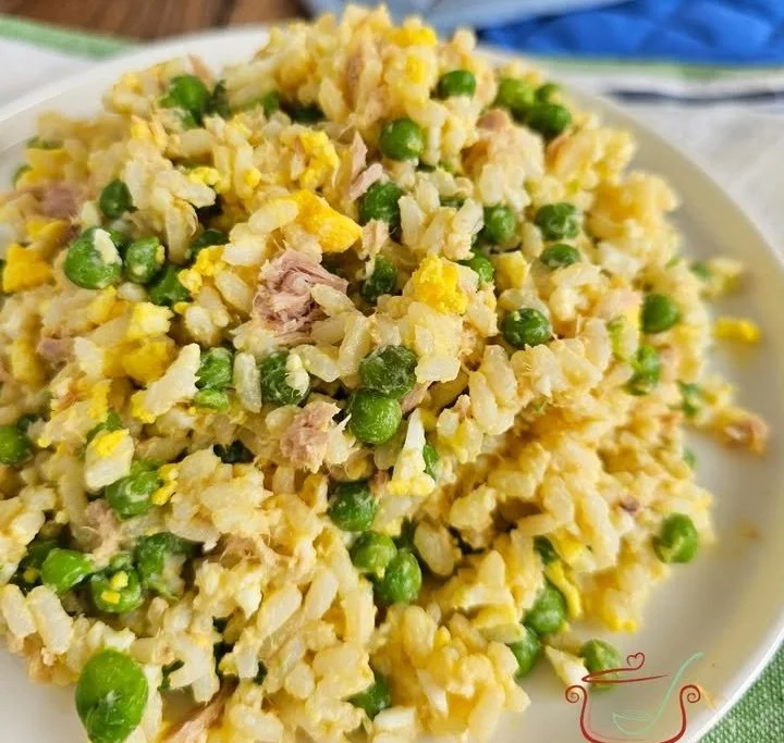 Insalata di riso con tonno, piselli e uova in un piatto colorato