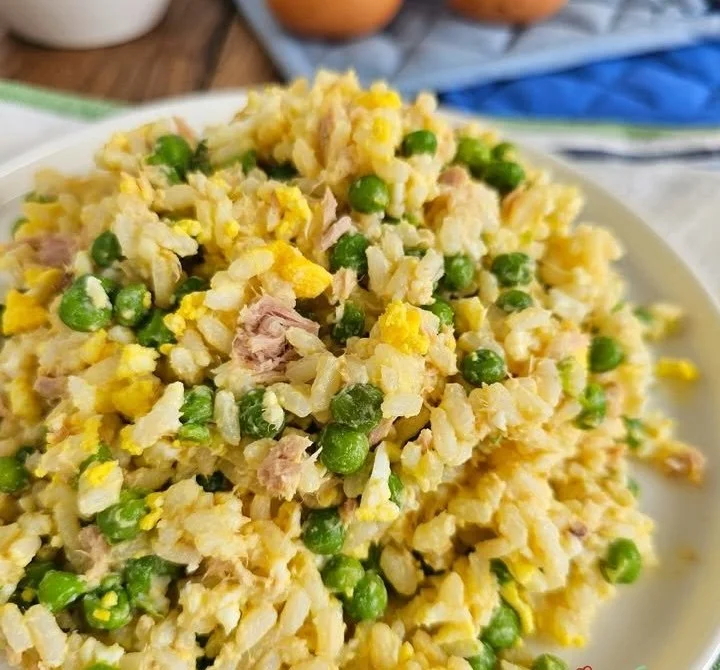 Insalata di riso con tonno, uova e piselli su un piatto colorato
