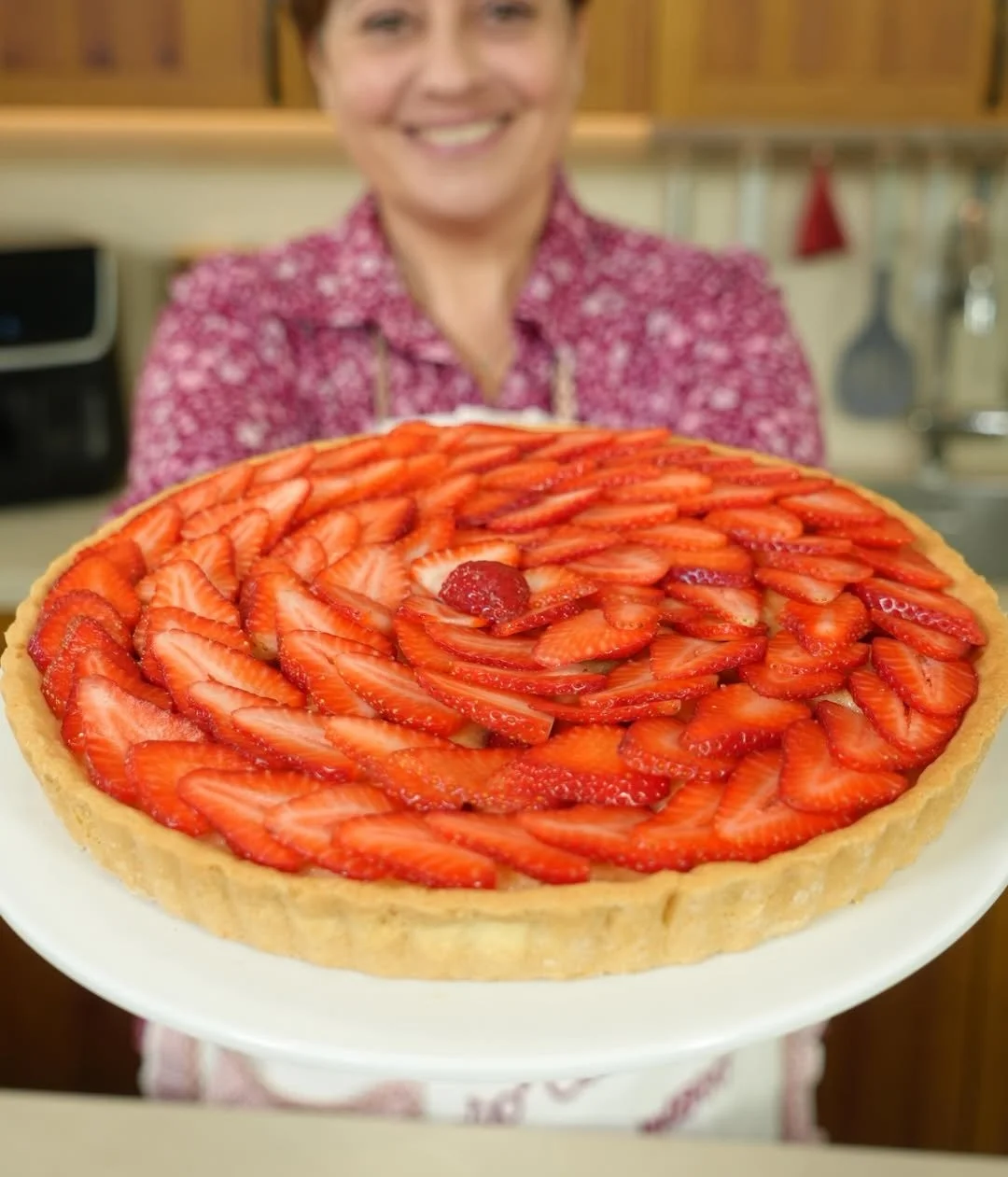 Crostata frangipane alle fragole appena sfornata, decorata con frutta fresca.
