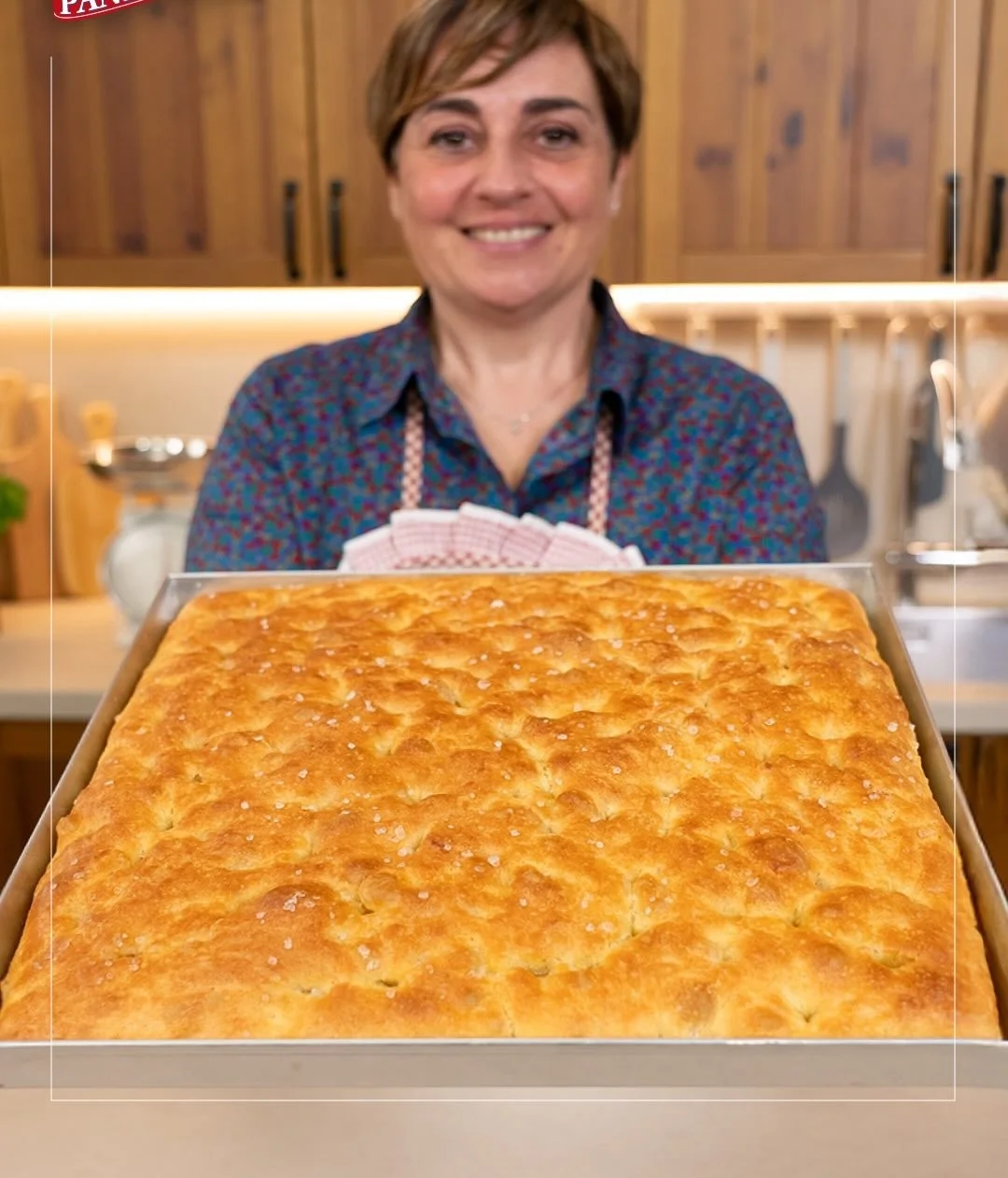 Focaccia alta e soffice appena sfornata con erbe aromatiche
