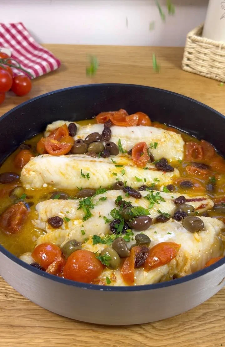 Merluzzo in padella con pomodorini e olive pronto da servire