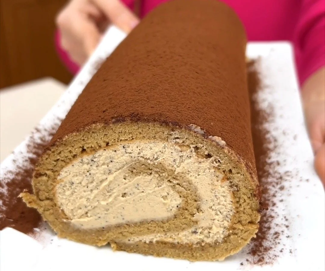 Rotolo al caffè decorato con crema e chicchi di caffè