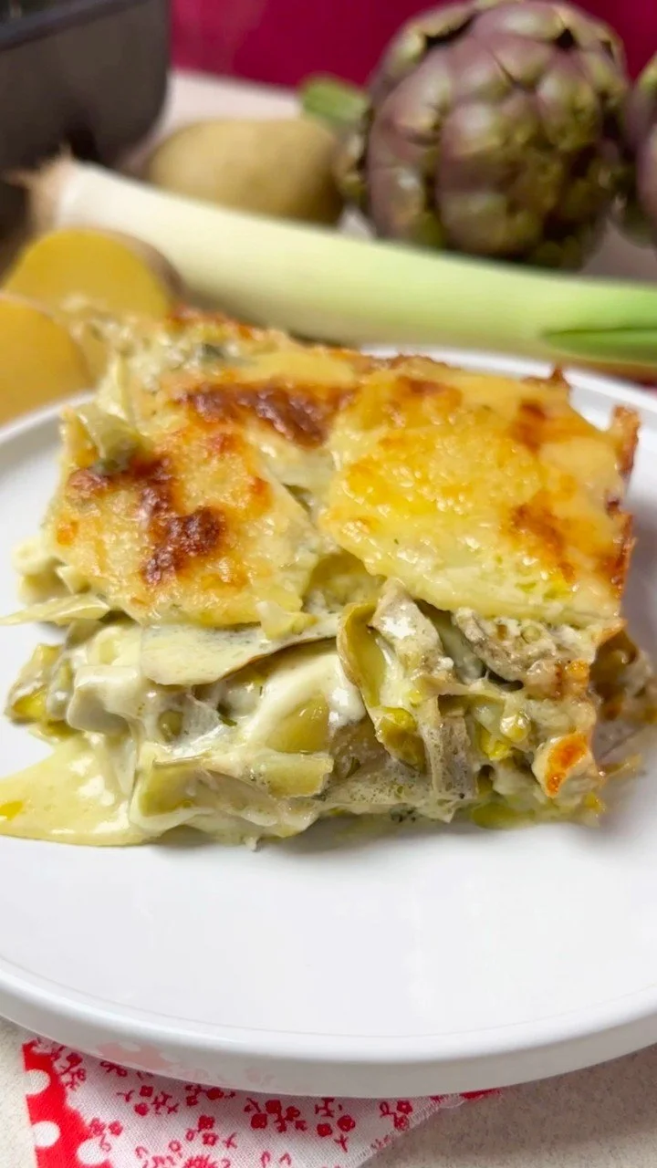 Sformato di patate e carciofi impiattato su un tavolo elegante.