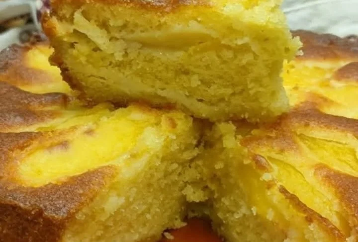 Fetta di torta alle mele appena sfornata con mele fresche e cannella.