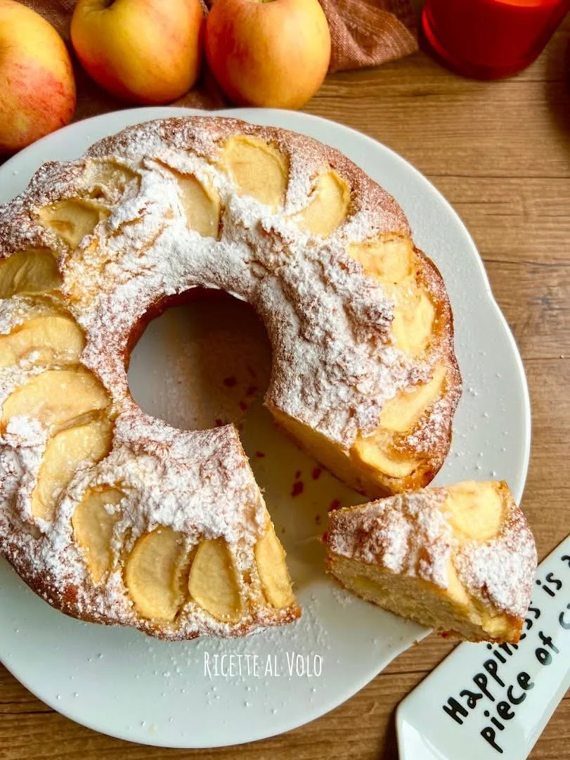 Ciambella alle mele con yogurt al cocco servita su piatto bianco