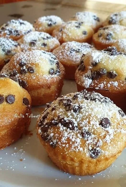 Muffin con gocce di cioccolato appena sfornati su un tavolo di legno