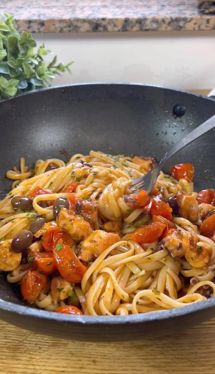 Pasta con Polpo, Pomodorini e Olive servita in un piatto elegante