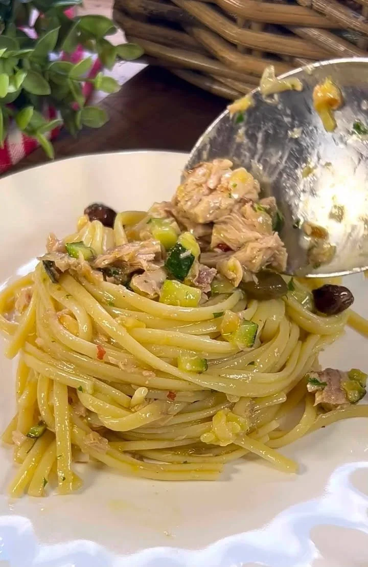 Pasta Tonno e Zucchine in Bianco servita su un piatto con decorazioni di erbe.