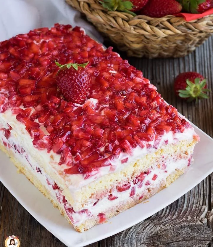 Torta alle Fragole fresca e invitante decorata con fragole e panna montata.
