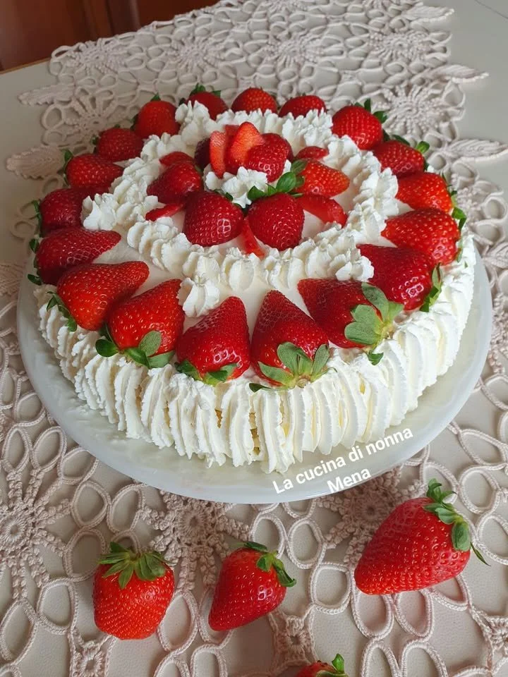 Una Torta di Panna e Fragole decorata con fragole fresche
