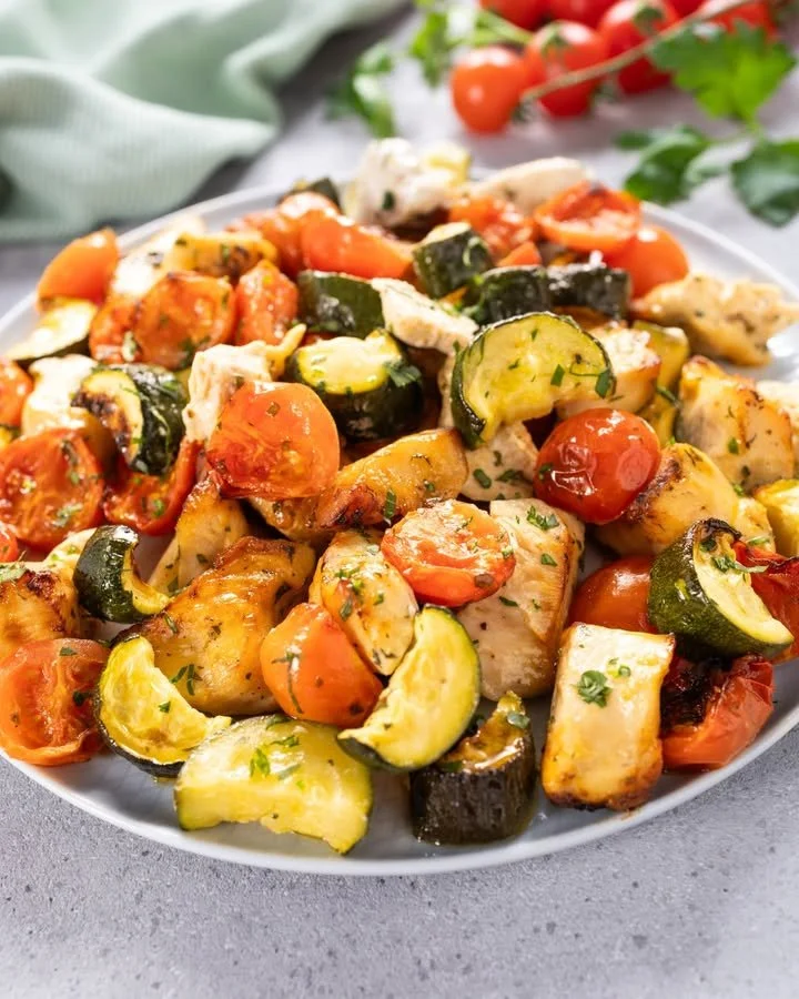 Bocconcini di pollo con zucchine e pomodorini serviti in un piatto