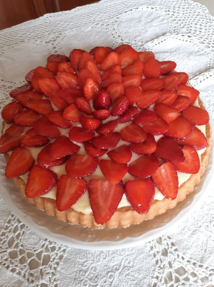 Crostata morbida con crema pasticcera e fragole su un piatto decorato