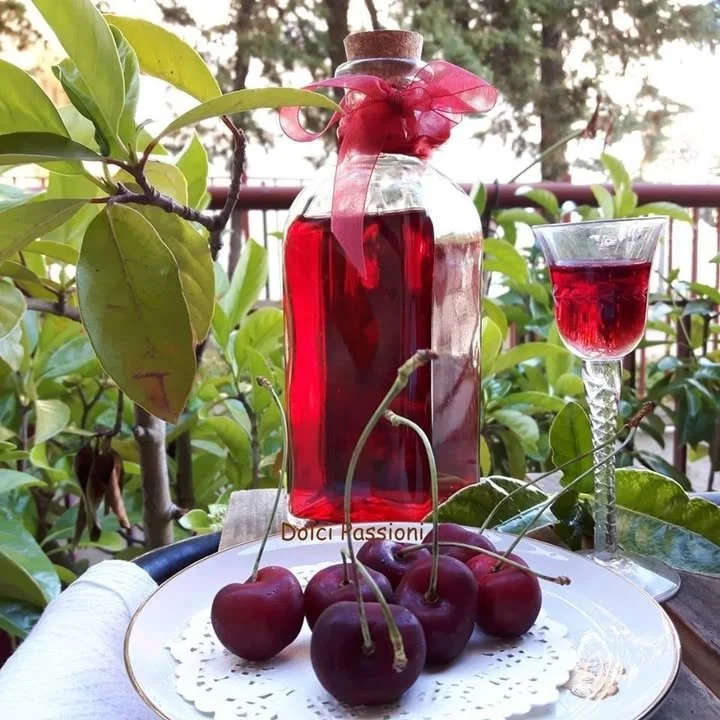 Liquore ciliegie fatto in casa con ciliegie fresche in una bottiglia elegante