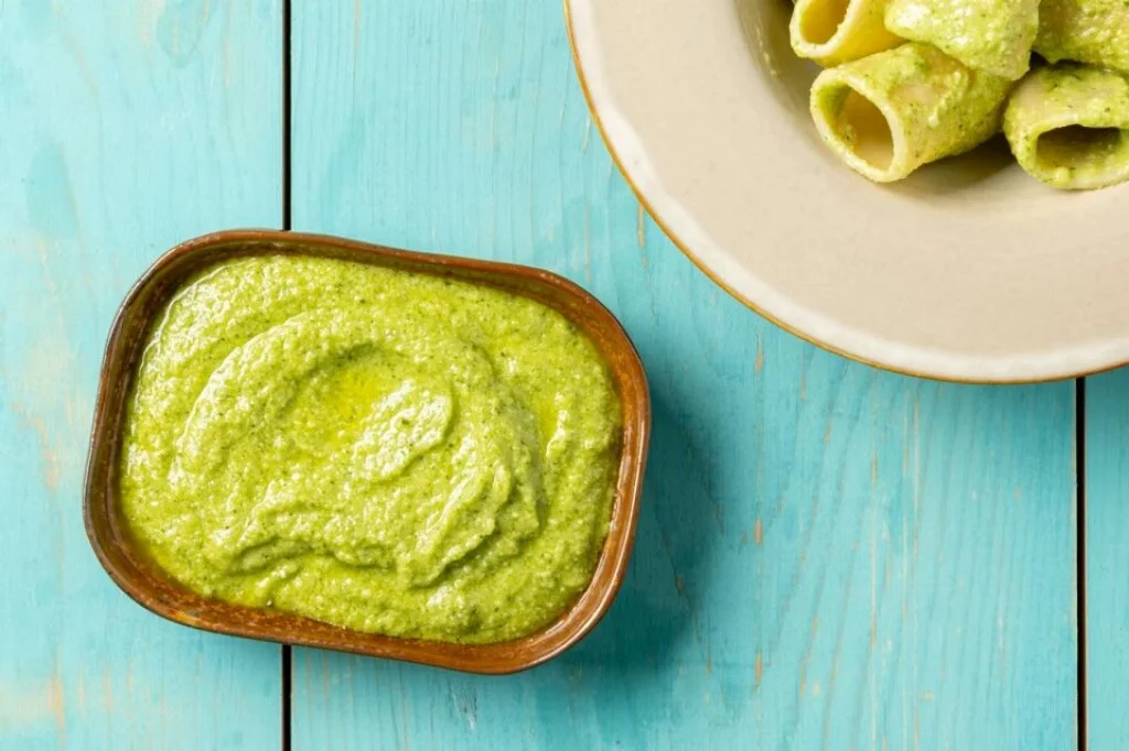 Pesto di zucchine crude preparato con ingredienti freschi per piatti estivi.