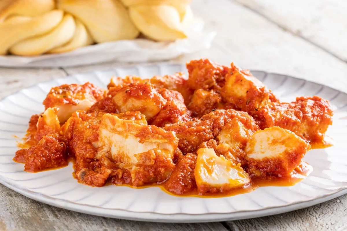 Baccalà alla livornese servito con pomodoro e olive