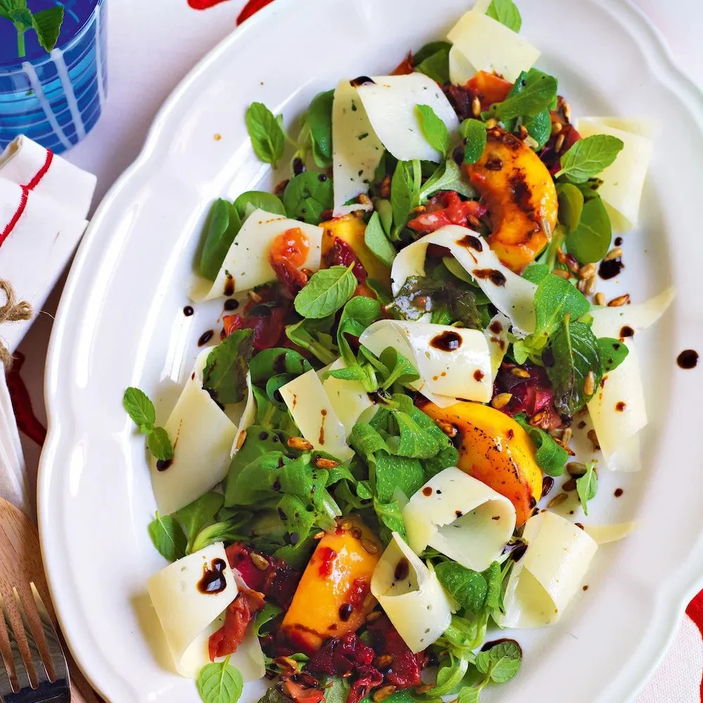 Insalata di valeriana e pesche con formaggio casera