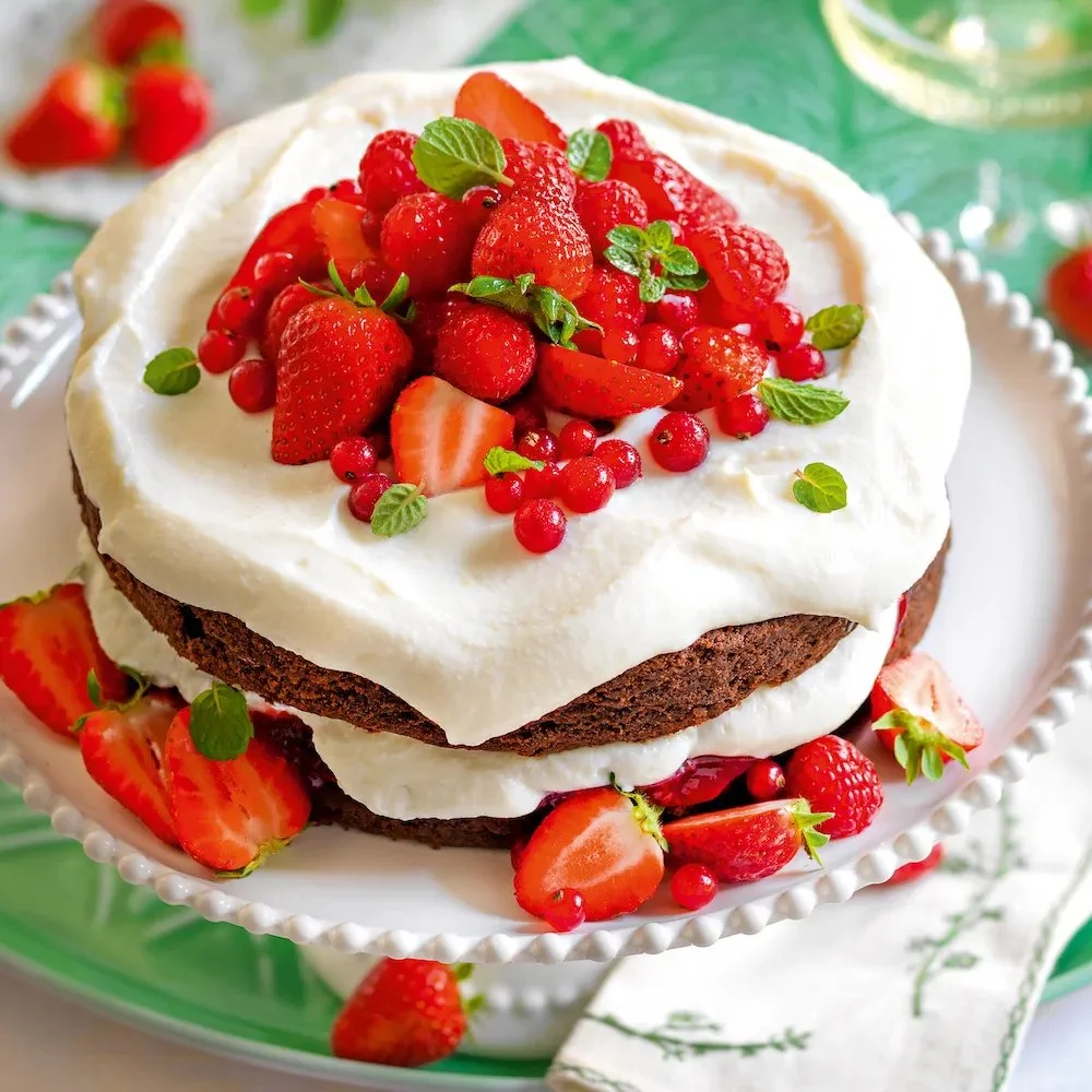 Torta al cioccolato con crema di ricotta e frutti rossi servita in un piatto