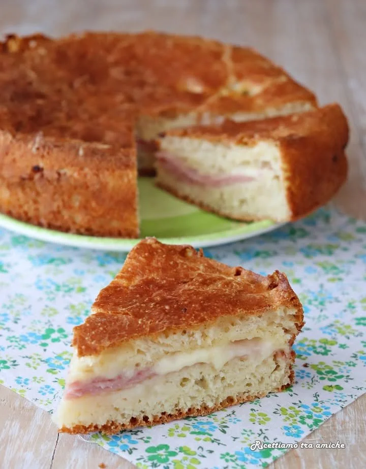 Torta rustica salata ripiena di prosciutto cotto e scamorza su un piatto
